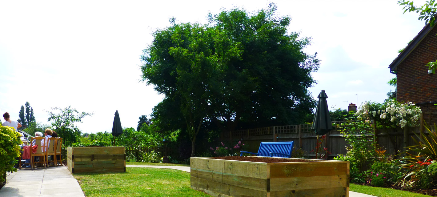 Octagonal green space with sensory planters, overlooking the allotments to the rear